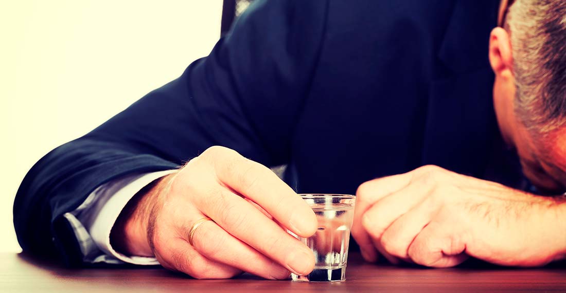 un homme avec un verre de vodka dort à la table